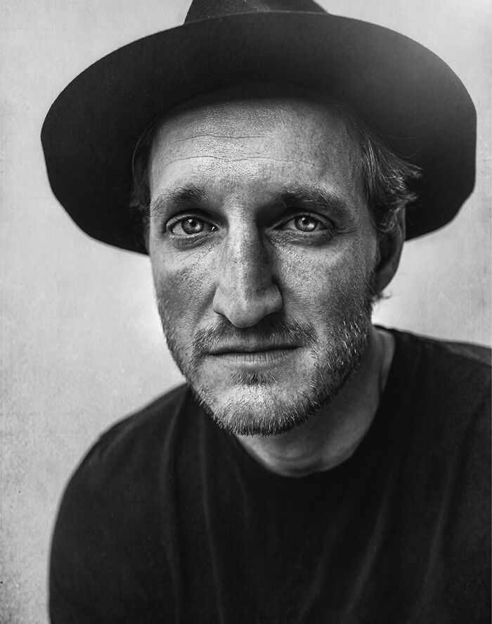A soulful portrait by Lee Jeffries featuring a man in a hat with a contemplative expression.