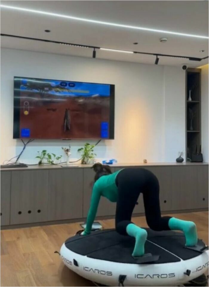 Person on a virtual reality exercise device in a modern living room, featuring humans-of-capitalism-pictures theme.