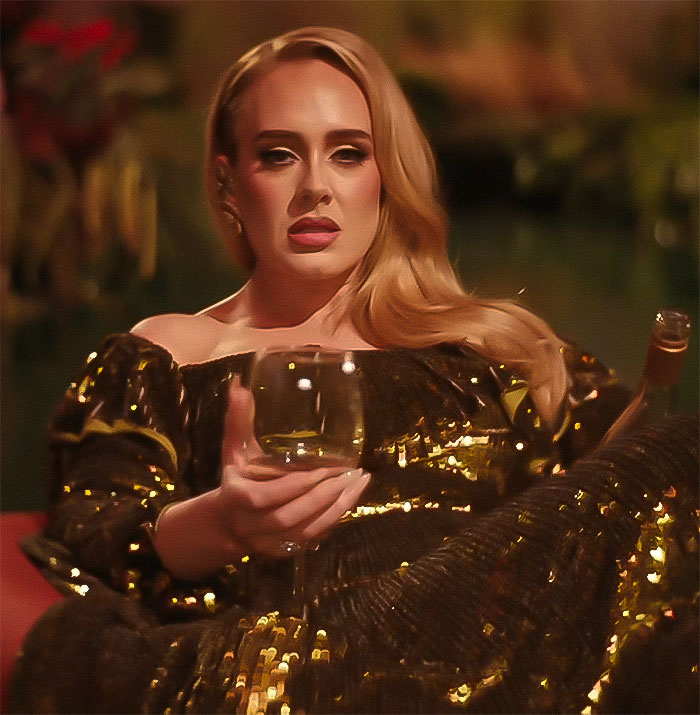 Adele in a glamorous setting, wearing a gold dress, holding a wine glass. Adele in a glamorous setting, wearing a gold dress, holding a wine glass.
