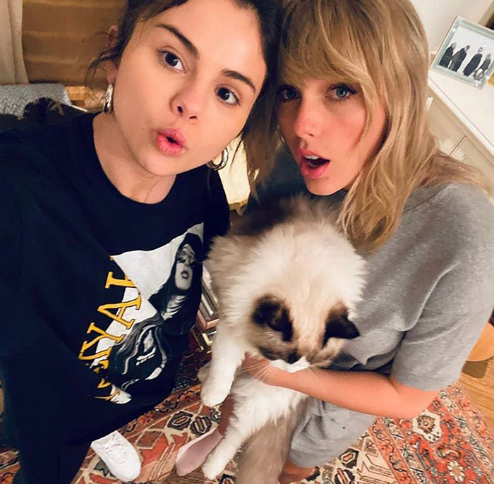 Selena Gomez and Taylor Swift posing with a cat. Selena Gomez and Taylor Swift posing with a cat.