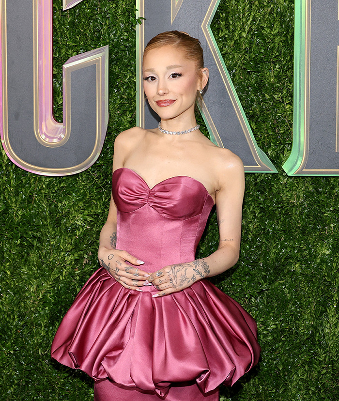 Ariana Grande in a satin dress, posing against a green backdrop. Ariana Grande in a satin dress, posing against a green backdrop.