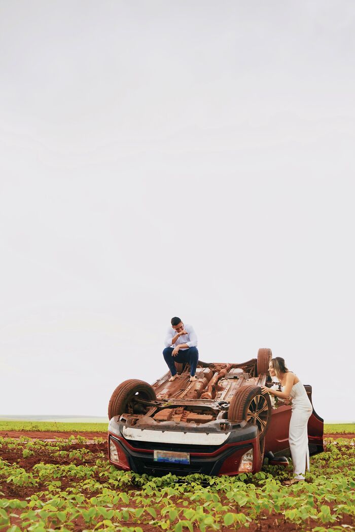 Couple poses by overturned car after accident, capturing unique photo shoot moment on the roadside field. Couple poses by overturned car after accident, capturing unique photo shoot moment on the roadside field.