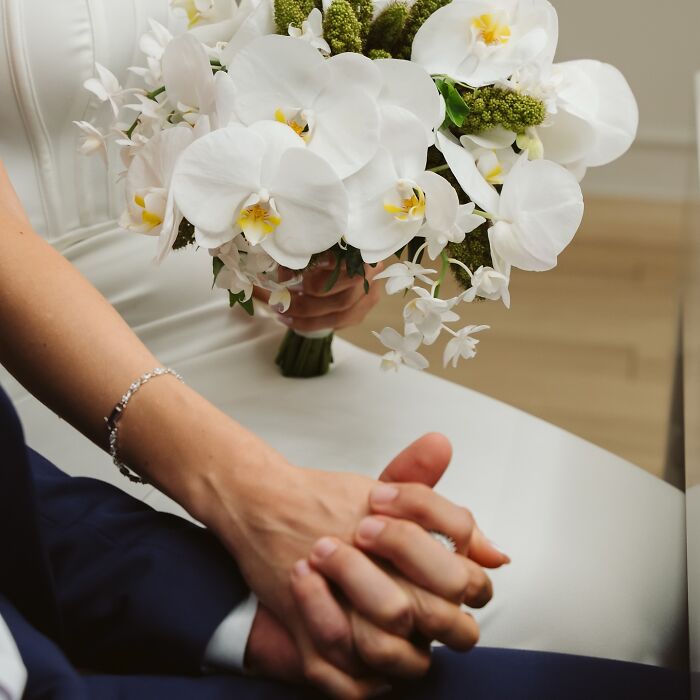 Couple holding hands with a wedding bouquet, symbolizing their unique story after a car accident en route to a photo shoot. Couple holding hands with a wedding bouquet, symbolizing their unique story after a car accident en route to a photo shoot.