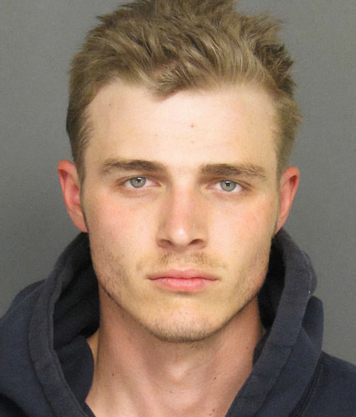 Jacob Miller in a mugshot, wearing a dark hooded sweatshirt. Viral criminal heartthrob image. Jacob Miller in a mugshot, wearing a dark hooded sweatshirt. Viral criminal heartthrob image.