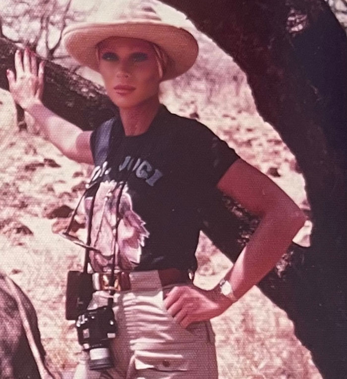 "Catwoman Jocelyn Wildenstein outdoors, wearing a wide-brimmed hat and posing confidently with a camera. "Catwoman Jocelyn Wildenstein outdoors, wearing a wide-brimmed hat and posing confidently with a camera.