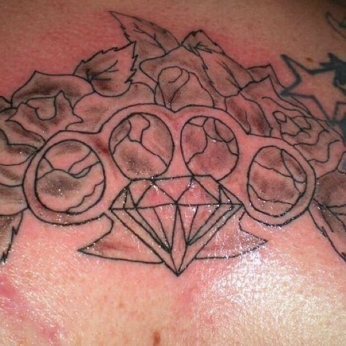 Amateur tattoo with uneven lines and a diamond shape on skin, showcasing one of the funny worst tattoo fails.