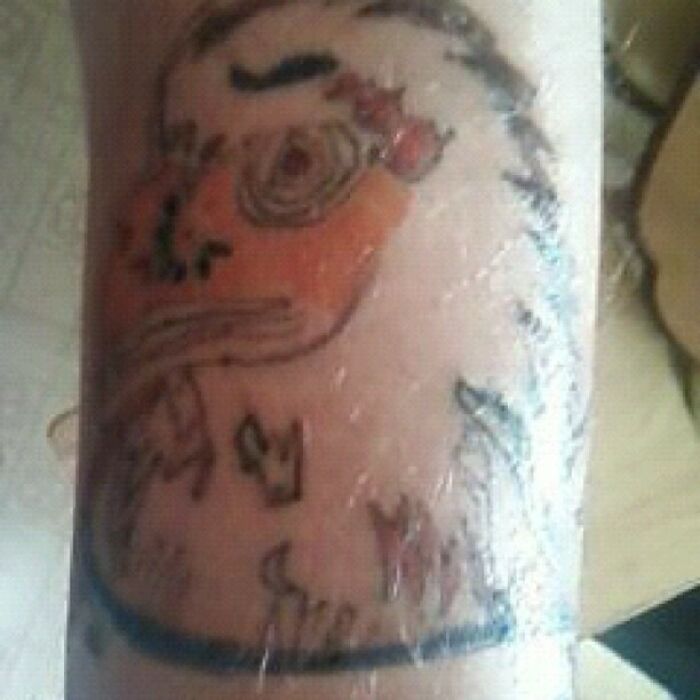 Blurry tattoo fail with a cartoon-like bird on arm, showcasing an amusing design error.