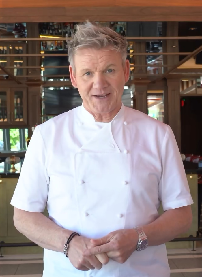 Chef Gordon Ramsay in a restaurant, wearing a white chef's coat, smiling. Chef Gordon Ramsay in a restaurant, wearing a white chef's coat, smiling.