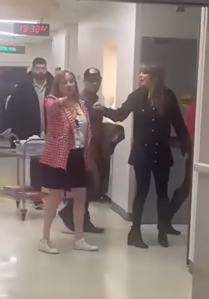 Taylor Swift in a hospital hallway, engaged in discussion, highlighting her visit to a children's hospital. Taylor Swift in a hospital hallway, engaged in discussion, highlighting her visit to a children's hospital.