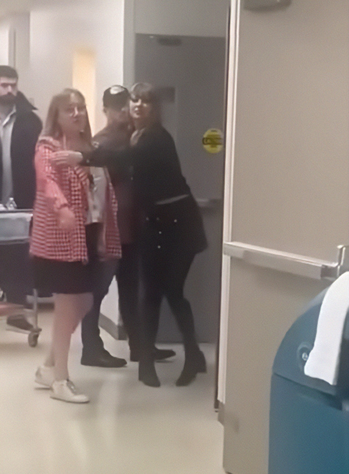 Taylor Swift in a hospital hallway, interacting with team members during a visit. Taylor Swift in a hospital hallway, interacting with team members during a visit.