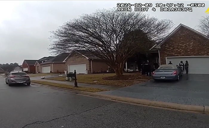 Street scene showing a home with police presence, related to a woman's arrest over reclaiming her house from a squatter. Street scene showing a home with police presence, related to a woman's arrest over reclaiming her house from a squatter.
