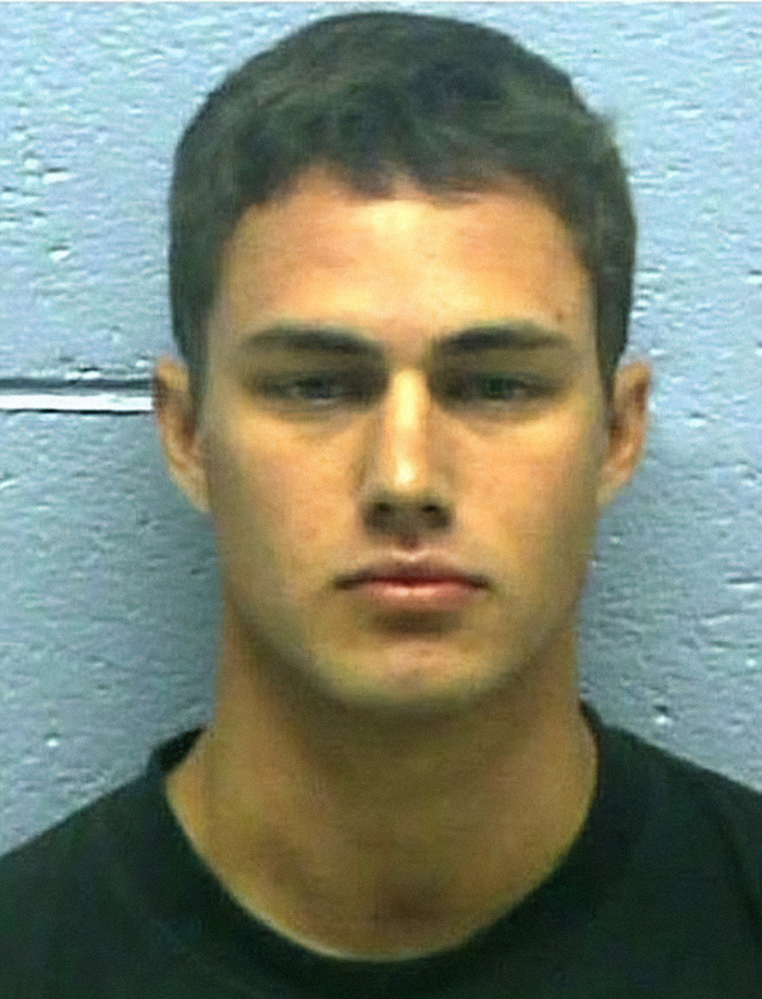 Taylor Kinney’s mugshot against a light blue wall, part of viral criminal heartthrobs series. Taylor Kinney’s mugshot against a light blue wall, part of viral criminal heartthrobs series.