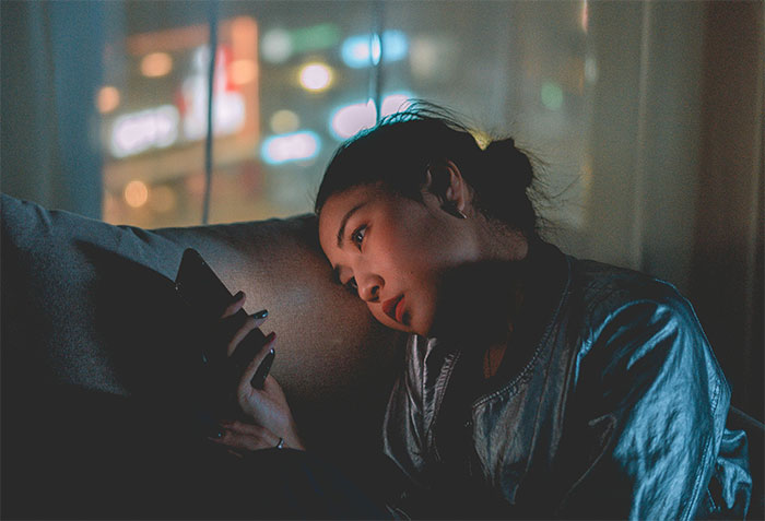 Woman looking at her phone, contemplating family events with her ex during Thanksgiving and Christmas. Woman looking at her phone, contemplating family events with her ex during Thanksgiving and Christmas.