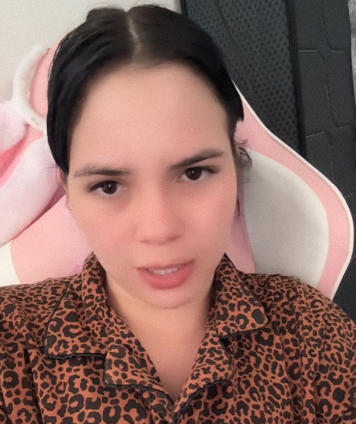 Nebrazkha in leopard print shirt with concerned expression, seated in a pink chair. Nebrazkha in leopard print shirt with concerned expression, seated in a pink chair.