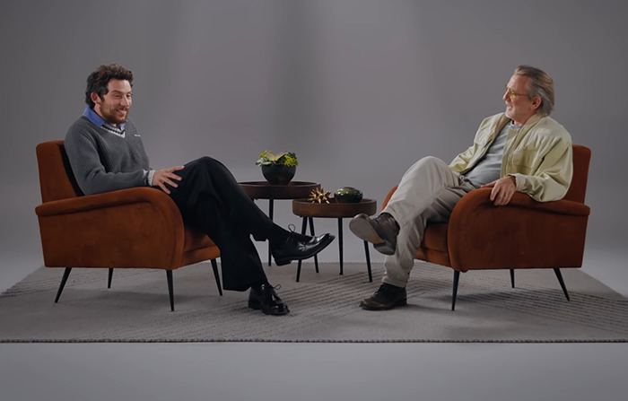 Daniel Craig and Josh O'Connor in armchairs having a casual conversation on set, discussing filming experiences. Daniel Craig and Josh O'Connor in armchairs having a casual conversation on set, discussing filming experiences.