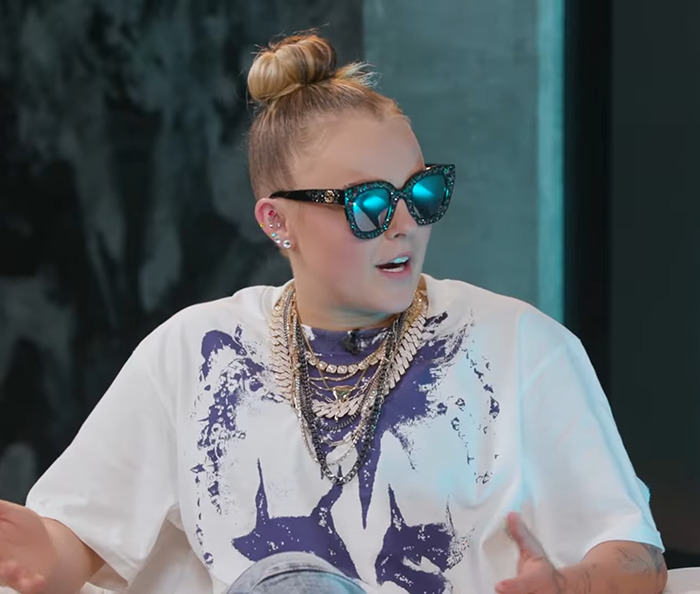 JoJo Siwa wearing sunglasses and a graphic tee. JoJo Siwa wearing sunglasses and a graphic tee.