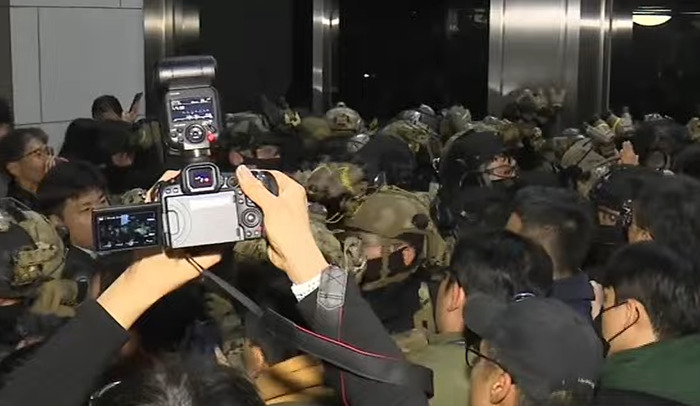 Parliament rejects South Korea's martial law, crowd of people and media cameras capturing the scene. Parliament rejects South Korea's martial law, crowd of people and media cameras capturing the scene.