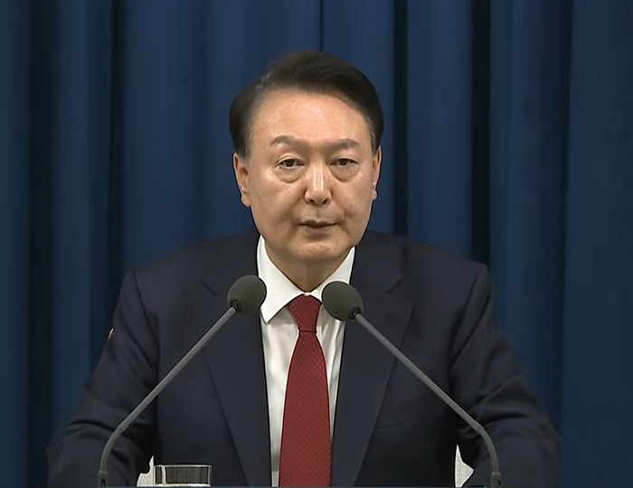 South Korea's president at a podium, addressing martial law rejection by parliament. South Korea's president at a podium, addressing martial law rejection by parliament.