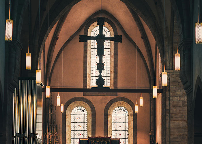 Gothic church interior with large cross and stained glass windows, related to wedding date change context. Gothic church interior with large cross and stained glass windows, related to wedding date change context.
