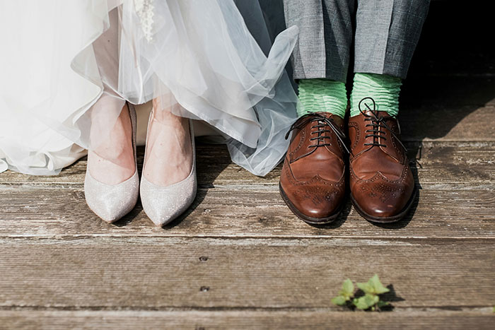 Bride and groom's shoes on wooden floor, highlighting child-free wedding theme. Bride and groom's shoes on wooden floor, highlighting child-free wedding theme.