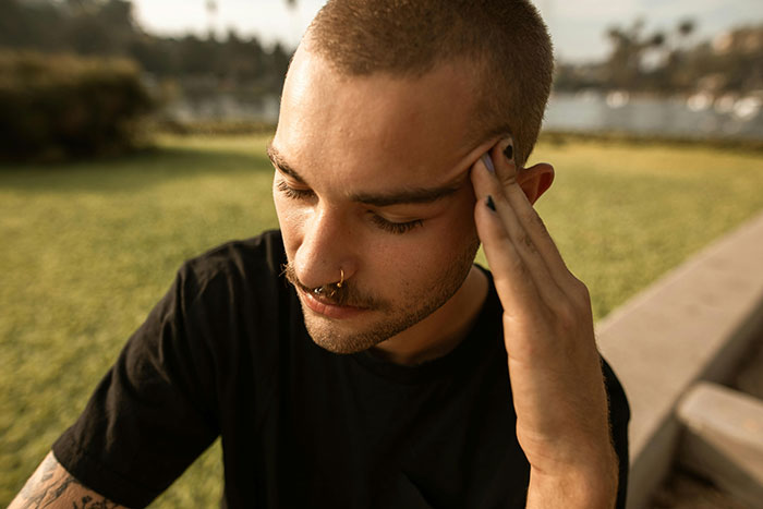 Man in a garden showing frustration, resting his head on his hand, dealing with unexpected wedding chores from family. Man in a garden showing frustration, resting his head on his hand, dealing with unexpected wedding chores from family.