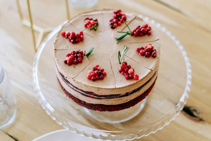 Chocolate cake with berries and rosemary on a glass stand, ready for a friend's birthday party celebration. Chocolate cake with berries and rosemary on a glass stand, ready for a friend's birthday party celebration.