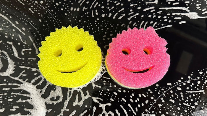 Two colorful sponges with smiley faces on a soapy surface, resembling christmas-gift-early ideas. Two colorful sponges with smiley faces on a soapy surface, resembling christmas-gift-early ideas.