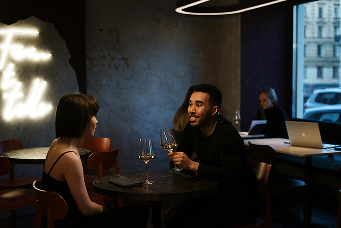 Couple on a Bumble date at a restaurant with wine glasses on the table. Couple on a Bumble date at a restaurant with wine glasses on the table.