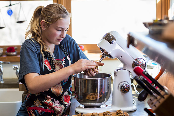 Teen girl baking Christmas cookies in kitchen using a stand mixer. Teen girl baking Christmas cookies in kitchen using a stand mixer.