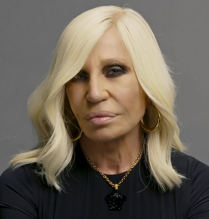 Blonde woman with long hair and gold necklace at musical premiere. Blonde woman with long hair and gold necklace at musical premiere.