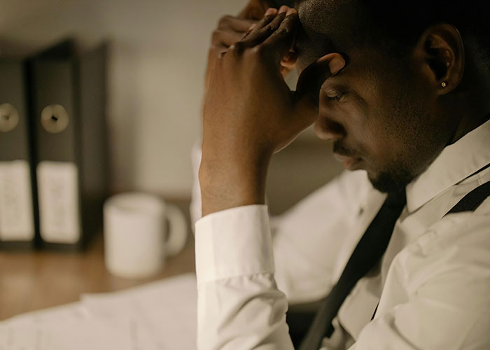 A stressed man at a desk, illustrating CEO management struggles.
