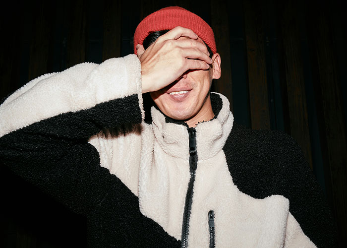 Person in a red beanie and fleece jacket covers face, illustrating themes related to fat-shaming. Person in a red beanie and fleece jacket covers face, illustrating themes related to fat-shaming.