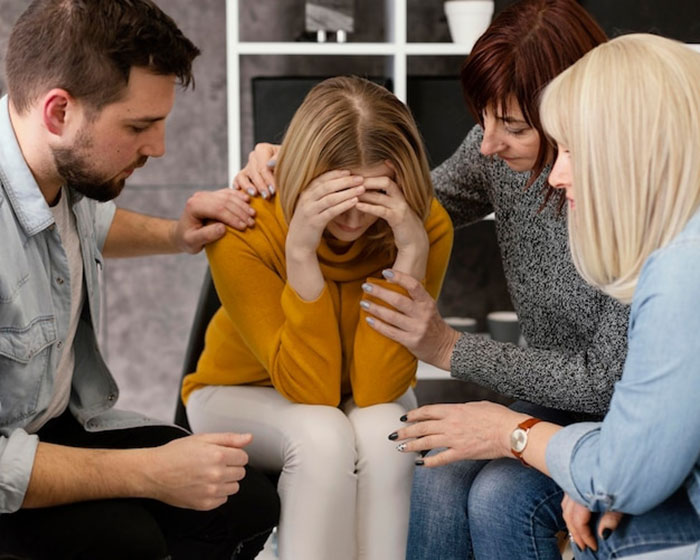 A group comforting a distressed woman after conflict involving father and daughter issues. A group comforting a distressed woman after conflict involving father and daughter issues.