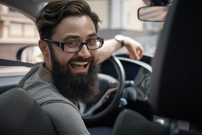 Man in car smiling, possibly planning a fiance house prank. Man in car smiling, possibly planning a fiance house prank.