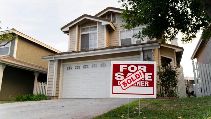 House with a "Sold" sign in the yard, part of a fiance surprise house prank. House with a "Sold" sign in the yard, part of a fiance surprise house prank.