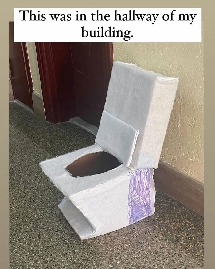 Homemade cardboard chair in a New York hallway, covered in white and purple fabric, adding humor to the space.