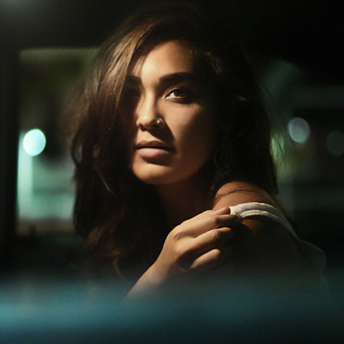 Woman in dim light with long hair, linked to green card marriage scam investigation. Woman in dim light with long hair, linked to green card marriage scam investigation.