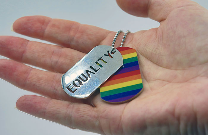 Hand holding Equality and rainbow flag dog tags, symbolizing LGBTQ+ support. Hand holding Equality and rainbow flag dog tags, symbolizing LGBTQ+ support.