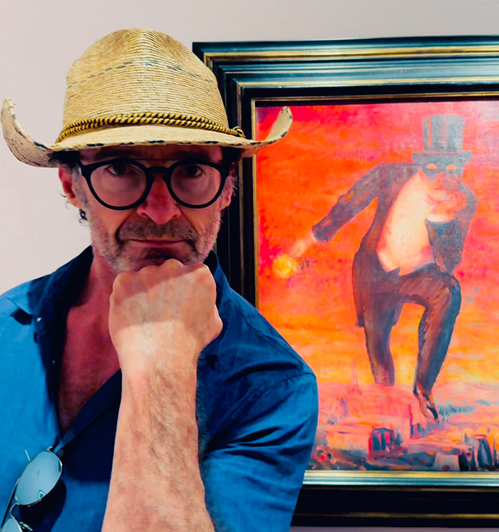 Mysterious man in glasses and straw hat poses near vibrant painting. Mysterious man in glasses and straw hat poses near vibrant painting.