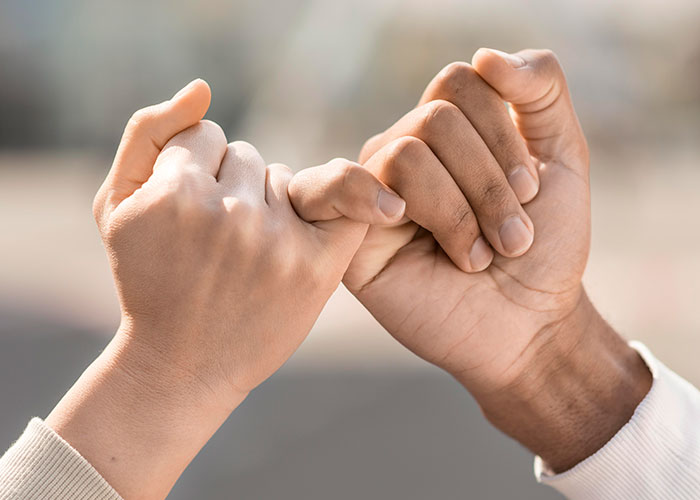 Two hands making a pinky promise, symbolizing support and understanding during a difficult time like surgery. Two hands making a pinky promise, symbolizing support and understanding during a difficult time like surgery.