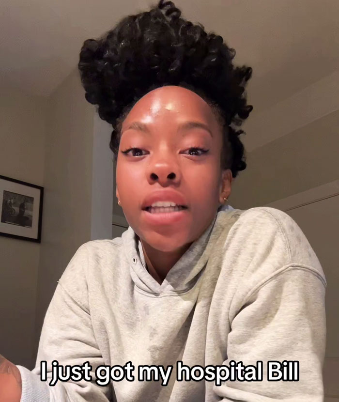 Person expressing shock about an insane hospital bill, wearing a hoodie indoors. Person expressing shock about an insane hospital bill, wearing a hoodie indoors.