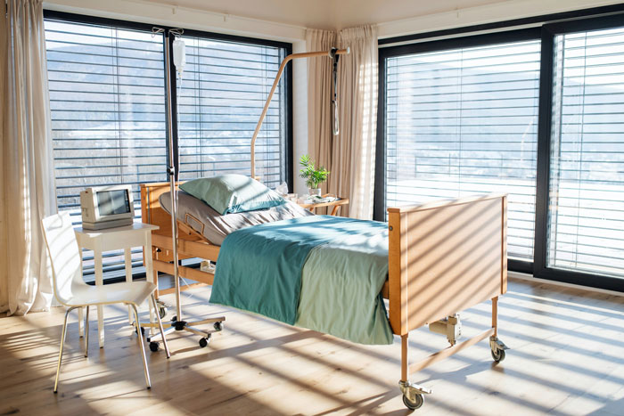Hospital room with bed and IV stand, sunlight streaming through window, highlighting potential for insane hospital bill. Hospital room with bed and IV stand, sunlight streaming through window, highlighting potential for insane hospital bill.