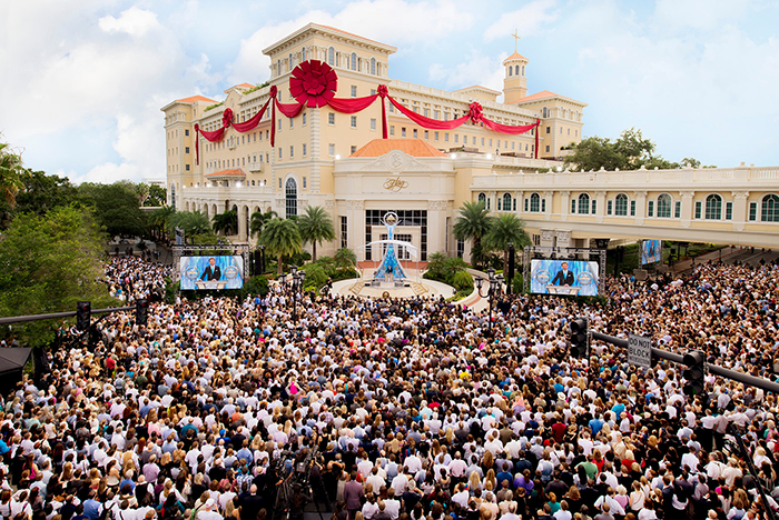 Large crowd gathered at a Scientology event outside a decorated building. Large crowd gathered at a Scientology event outside a decorated building.