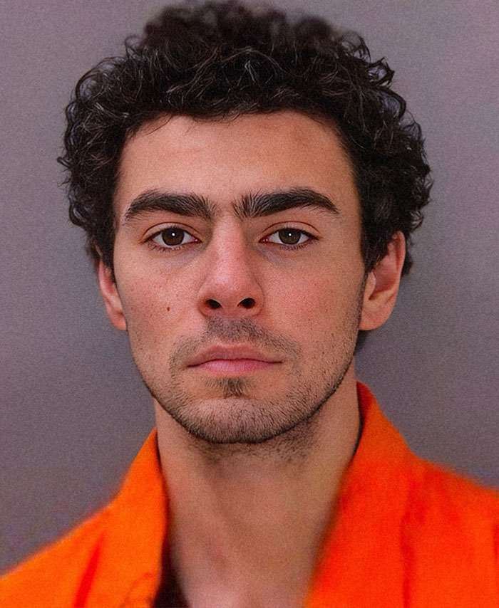 Luigi Mangione mugshot, Luigi in an orange shirt looking directly at the camera. Luigi Mangione mugshot, Luigi in an orange shirt looking directly at the camera.