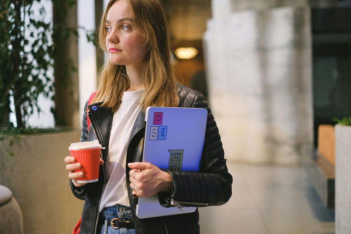 Woman holding a coffee cup and a laptop, representing mom-relationship-drama in a modern setting. Woman holding a coffee cup and a laptop, representing mom-relationship-drama in a modern setting.