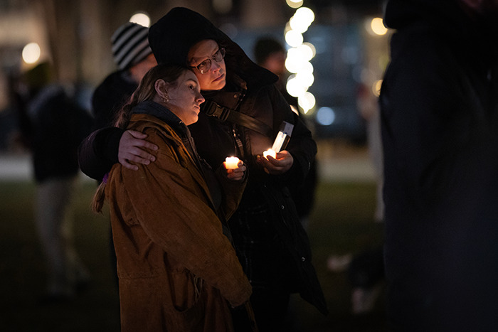 People holding candles at a vigil, reflecting on Wisconsin school tragedy and family secrets. People holding candles at a vigil, reflecting on Wisconsin school tragedy and family secrets.