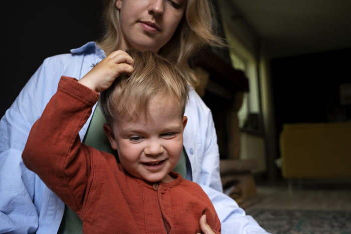Person holding a smiling toddler, conveying parental concern for child safety. Person holding a smiling toddler, conveying parental concern for child safety.