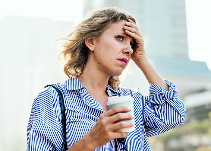 A frustrated woman holds a coffee cup, standing outdoors, learning a lesson about parking in driveways. A frustrated woman holds a coffee cup, standing outdoors, learning a lesson about parking in driveways.