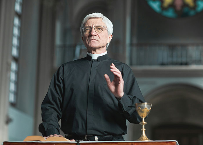 A person in clerical attire stands in a church near a chalice, illustrating persistent Mormons learning a lesson. A person in clerical attire stands in a church near a chalice, illustrating persistent Mormons learning a lesson.