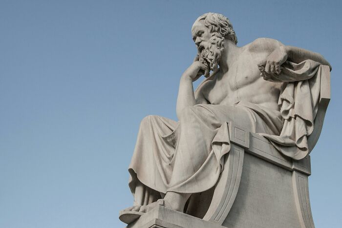 Statue of a philosopher on a pedestal, depicting historical occupations.